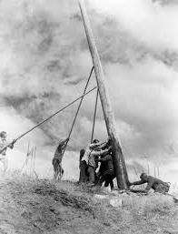 Workers putting up a utility pole